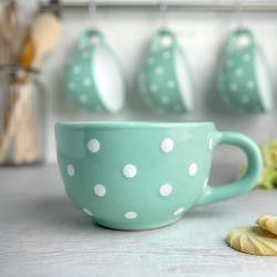 Tasse en céramique bleue turquoise, pois blancs, artisanale en situation